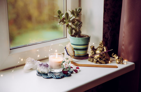 Feng Shui altar at home in living room or bed room. Attracting wealth and prosperity concept. Crystal clusters, wire tree with gemstones, golden smiling Buddha figure on table window sill.  - Powered by Adobe