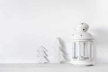 Christmas holiday background with white lantern and white fir trees on the white background with copy space