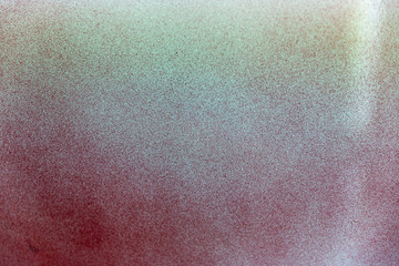 Green & red spray paint effect on white plastic surface.