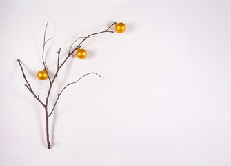 Holiday greeting card. Flat lay, minimal nature christmas concept. Copy space. Branch decorated with small christmas golden balls.