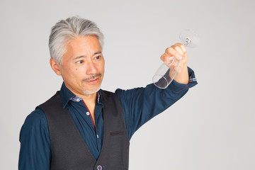 Hombre de mediana edad de origen japonés con una copa de Champagne vacía