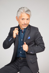 Hombre de origen japonés, elegante poniéndose bien la solapa de la americana