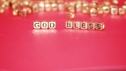 Gold beads with words 'TAX' on the pink background.
