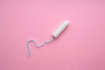 Menstrual tampon on a pink background. Menstruation cycle. Hygiene and protection.