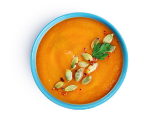 Pumpkin cream soup with seeds isolated on white background.