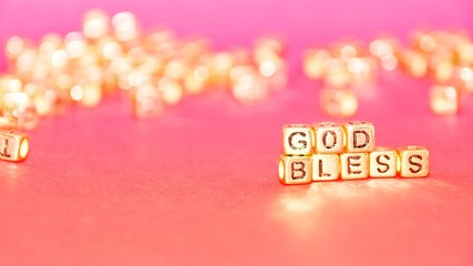 Gold beads with words 'TAX' on the pink background.