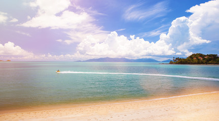 Beautiful tropical seascape. Ocean waves and cloudy sky background. Crystal-blue sea, island, water bike. Ocean water nature, beach relax. Summer sea vacation