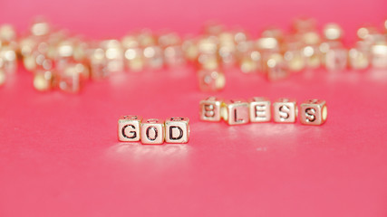 Gold beads with words 'TAX' on the pink background.