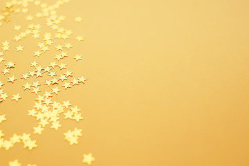 Golden stars on a yellow background, holiday concept