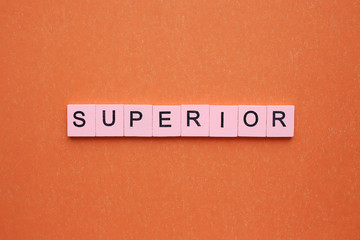 Superior word wooden cubes on an orange background.