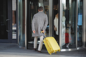 Man with a yellow suitcase.