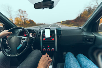 car travel concept autumn highway phone with white screen on dashboard