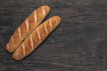 Baguette on wooden background and top view.