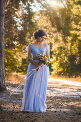 Fototapeta premium happy bride with a bouquet is walking the green park