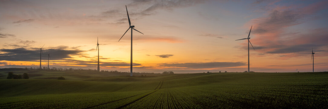windmills on a field in Germany during a beautiful multicolored sunrise
