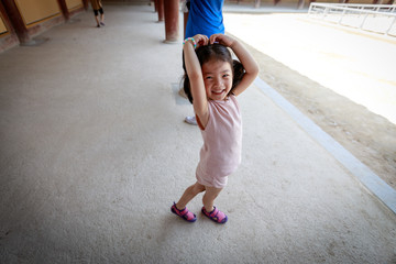 Cute little asian girl standing outside