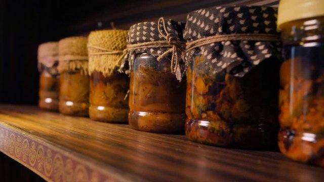 Pan shot of ready Indian pickles / achar kept in bottles for sale. 