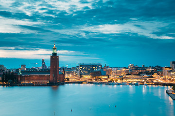 Stockholm, Sweden. Scenic Skyline View Of Famous Tower Of Stockholm City Hall. Building Of Municipal Council. Famous Popular Destination Place In Dusk Lights. Night Lighting