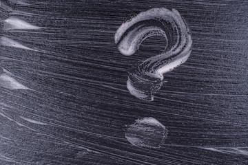 Question mark made from soap foam on a black background. Abstract foam texture on black background. Soap foam bubbles abstract dark background