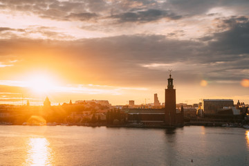Stockholm, Sweden. Scenic Skyline View Of Famous Tower Of Stockholm City Hall. Building Of Municipal Council Stands On Kungsholmen Island. Sunshine Above Famous And Popular Place In Sunset Sunrise