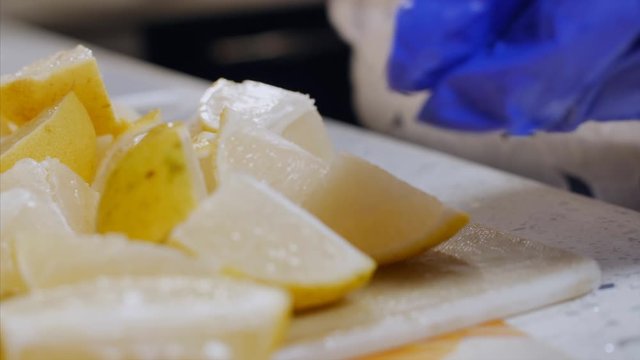 A women cutting the juicy lemon into pieces for Indian pickle / achar. 