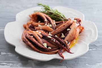 boiled octopus with garlic on white plate