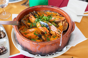 seafood rice in brown ceramic pot in restaurant