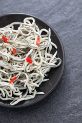 Traditional Spanish food. Gulas with oil on white plate.