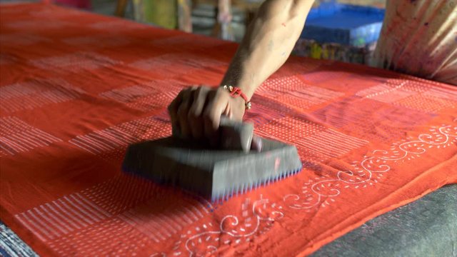 Shot of man block printing on a cotton fabric. 