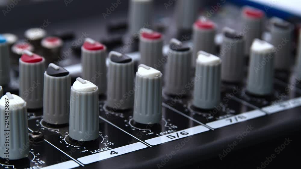 Poster tracking left shot of a audio mixer desk with many buttons