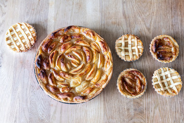 Homemade apple pies on a wooden table in a kitchen
