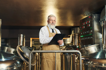 Brewery worker monitoring brewering process.