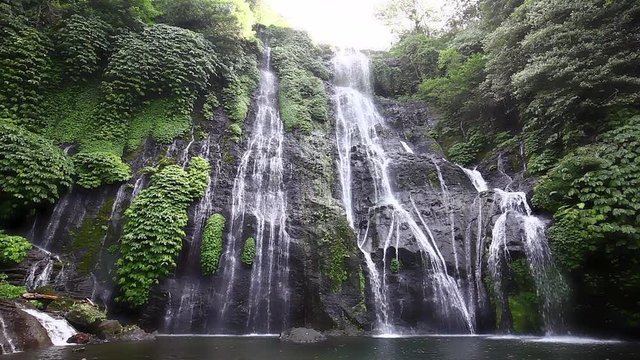 Beautiful Banyumala twin waterfalls among the green rainforest in a sunny day in Wanagiri village in Buleleng, North Bali, Indonesia.