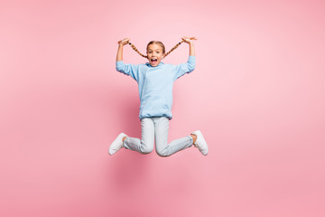 Full body profile photo of pretty little lady jumping high holding cool long braids in hands enjoy...