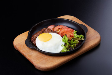Pan winth fried egg, sliced tomatoes, salad and cutlet