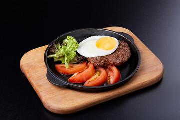 Pan winth fried egg, sliced tomatoes, salad and cutlet