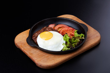 Pan winth fried egg, sliced tomatoes, salad and cutlet