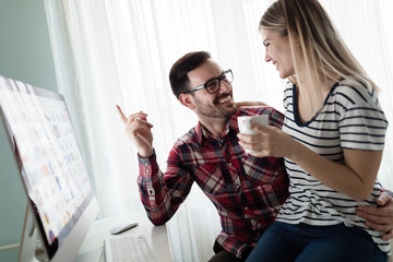 Young couple of designers working on computer