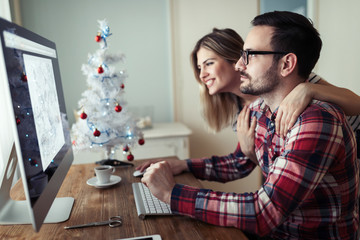 Young couple of designers working on computer