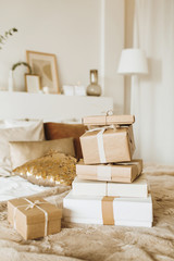 Christmas / New Year composition. Handmade winter holidays craft gift boxes on bed with golden pillow. Festive concept.