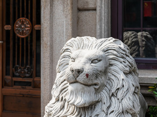 Detail of the head of a marble statue of lion on Duolun Road, a pedestrian street for historic buildings, events and residences of prominent historical people in Hongkou District, Shanghai., China.