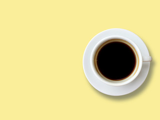Top view of Black coffee in white cup isolated on the pastel yellow background. Copy space and pastel concept.