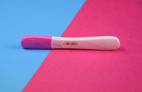 Positive pregnancy test stock images. Pregnancy test on a pink and blue background. White plastic pregnancy test girl or boy