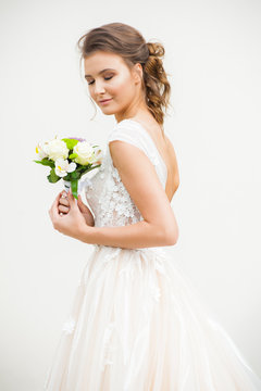 Beautiful happy bride in long wedding dress with wedding bouquet