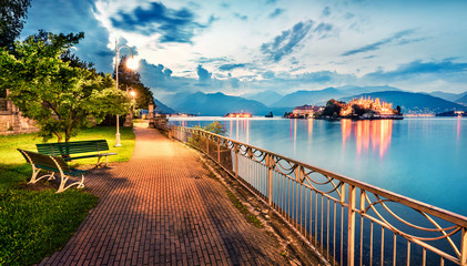 Splendid evening cityscape of Stresa town. Wonderful summer susnset on Maggiore lake with Bella island on background, Province of Verbano-Cusio-Ossola, Italy, Europe. Traveling concept background.