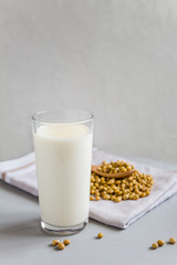 Soy milk in a glass glass. Vegetarian food. Organic products, healthy food concept. Vertical orientation, side view, copy space.