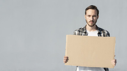 Young man holding board with mock-up