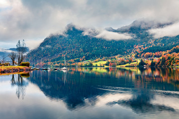 Fototapeta premium Foggy autumn view of Grundlsee lake. Wonderful morning scene of Brauhof village, Styria stare of Austria, Europe. Colorful view of Alps. Traveling concept background.