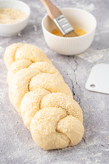 Raw loaf of challah Jewish bread on a light background. Copy space.