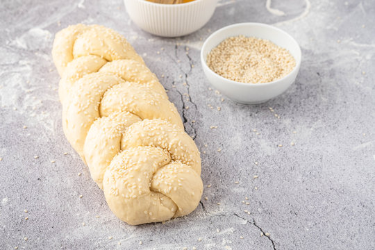 Raw loaf of challah Jewish bread on a light background. Copy space.